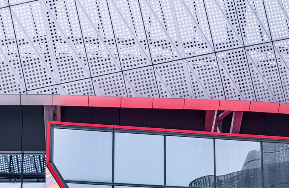 Perforated metal facade panels on Chongqing sports venue exterior