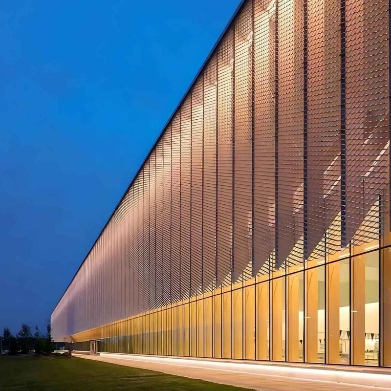 Expanded stainless steel facade cladding with a geometric open mesh structure