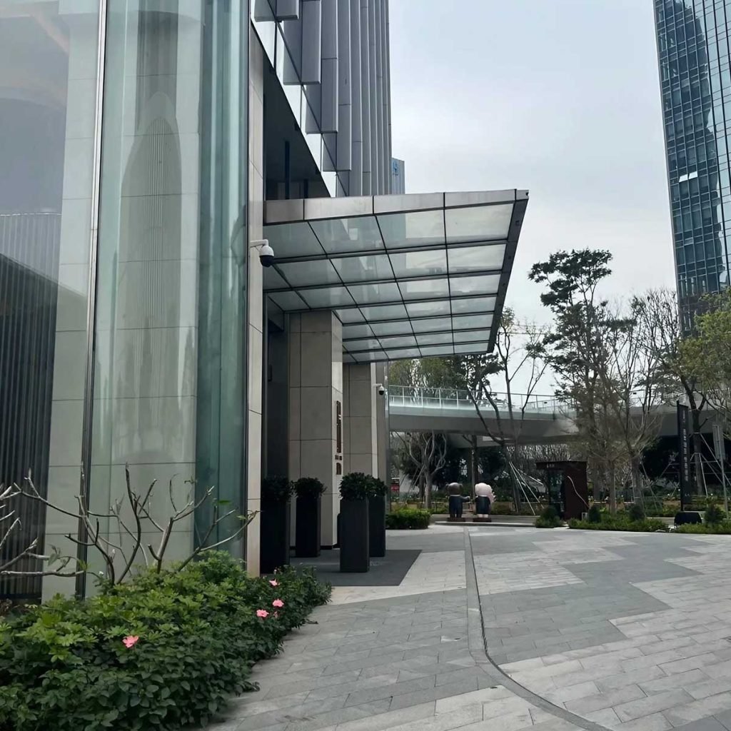 Custom stainless steel glass canopy manufactured for architectural entrance applications