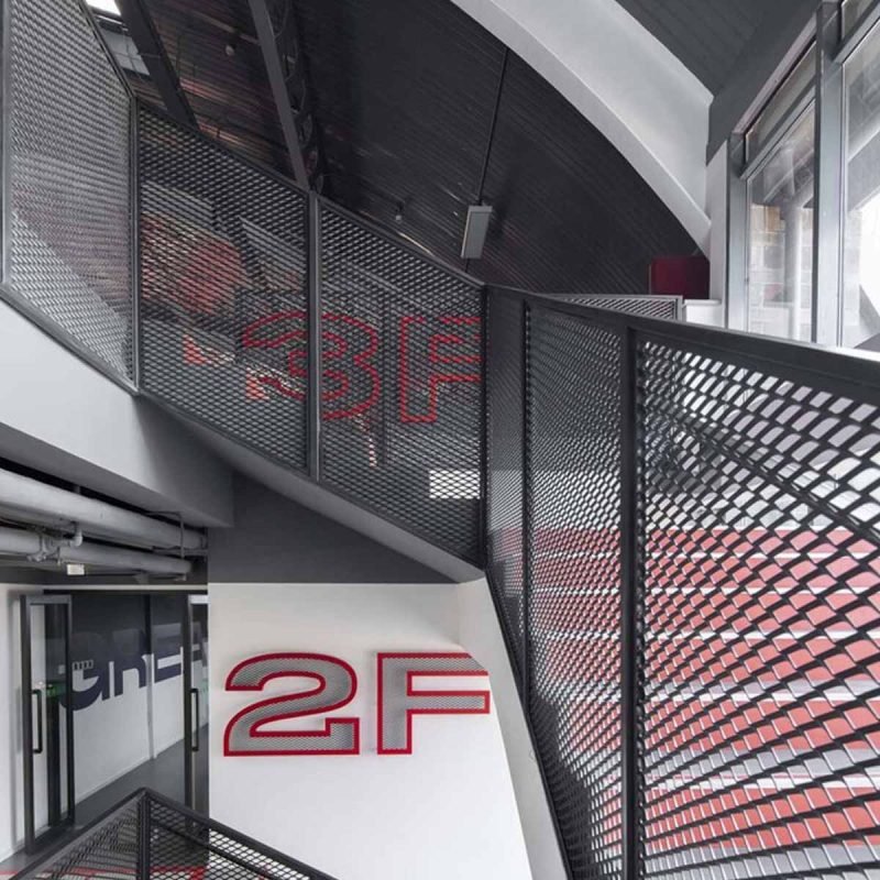 Custom expanded metal mesh railing panels installed along interior stairways