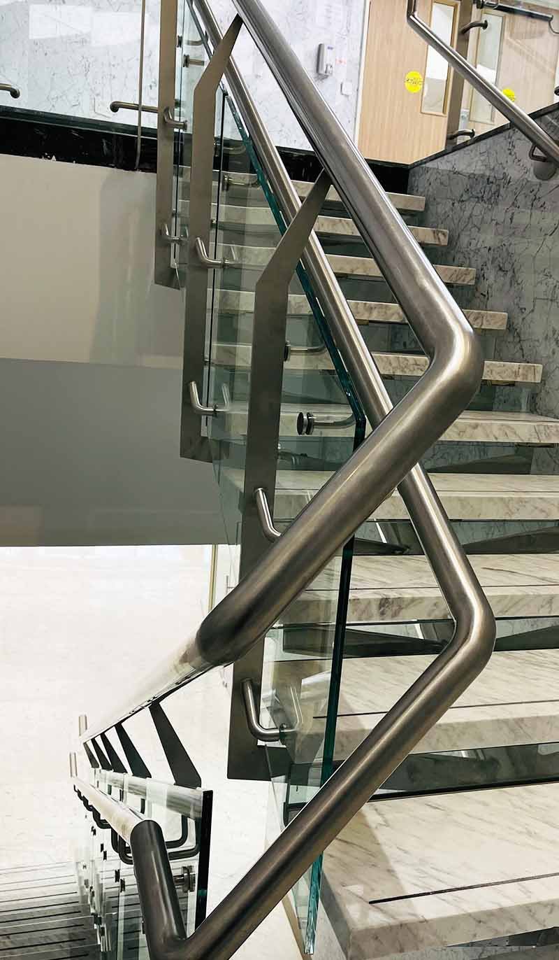 Custom architectural glass balustrade and stainless steel railing system for a modern interior