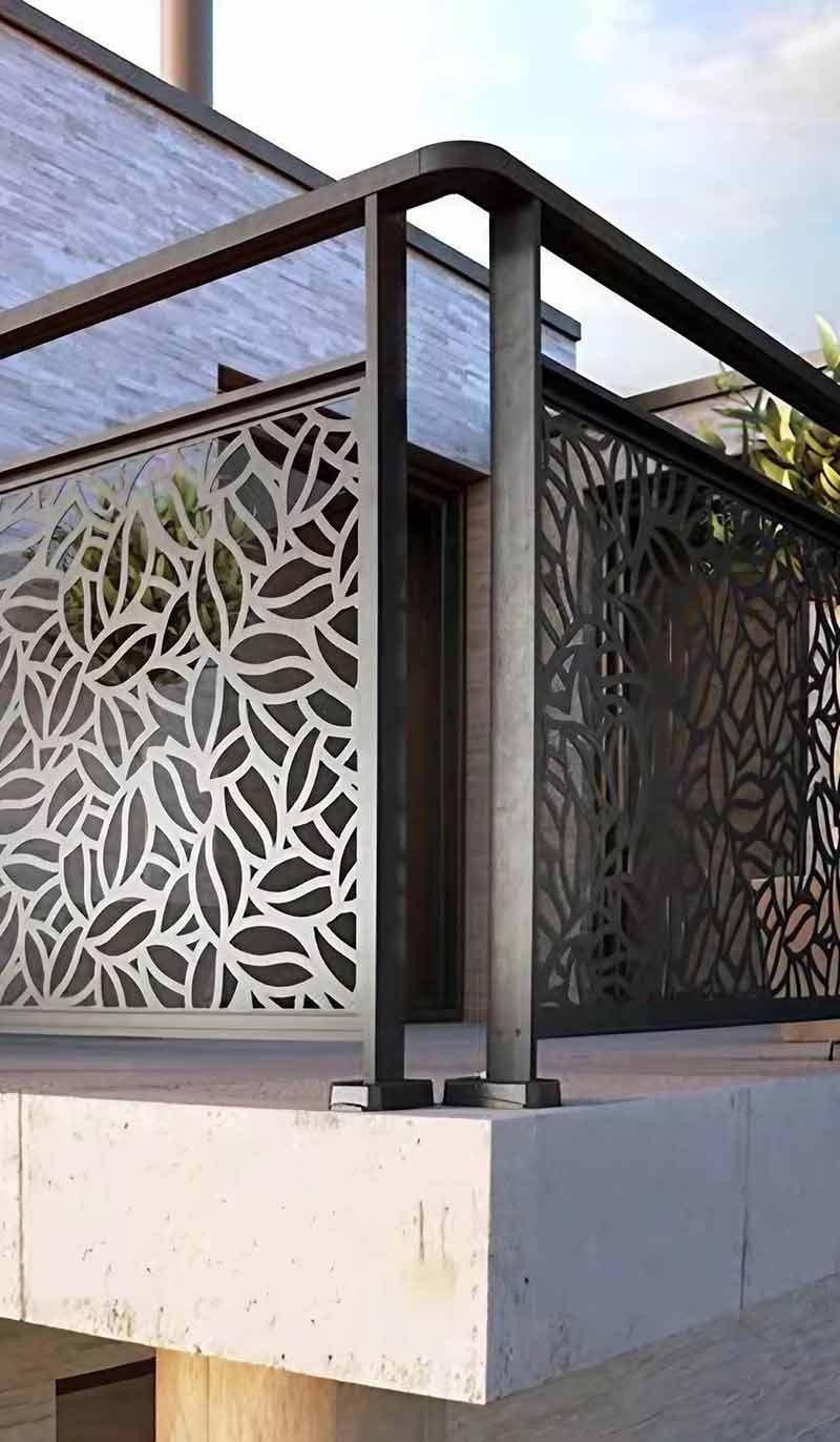 Custom architectural metal railing and balustrade system with laser-cut pattern designs for a modern building