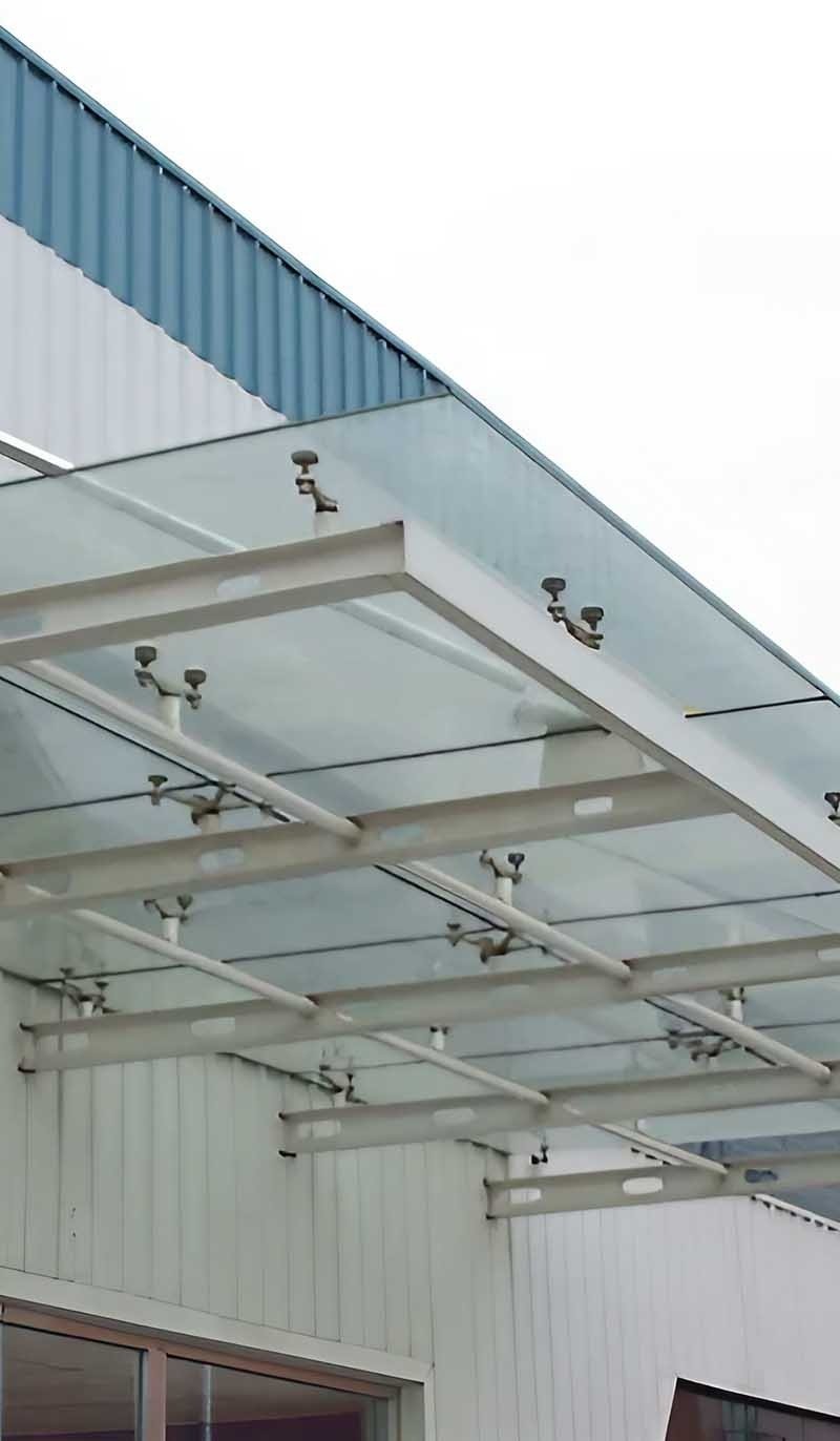 Stainless steel canopy with glass panels fitted above a building entrance