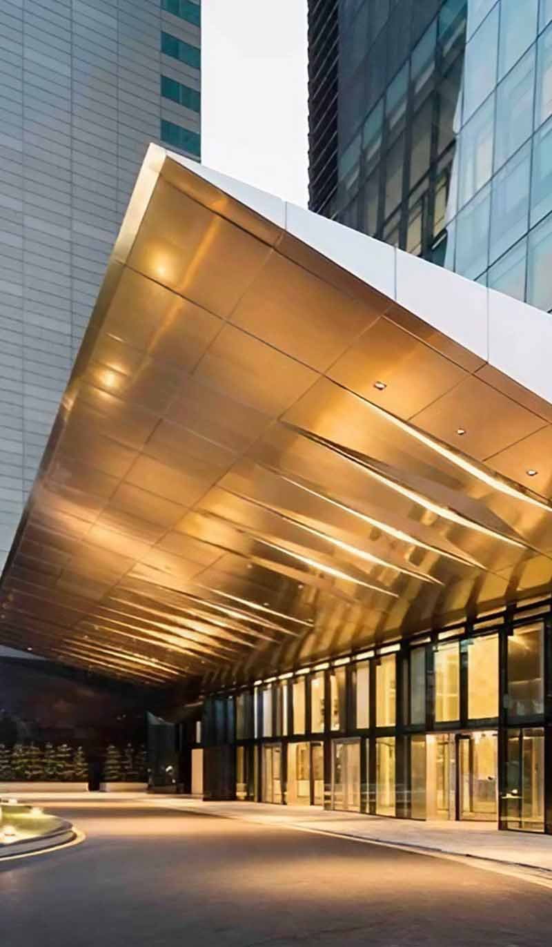 Stainless steel glass canopy installed above a modern building entrance
