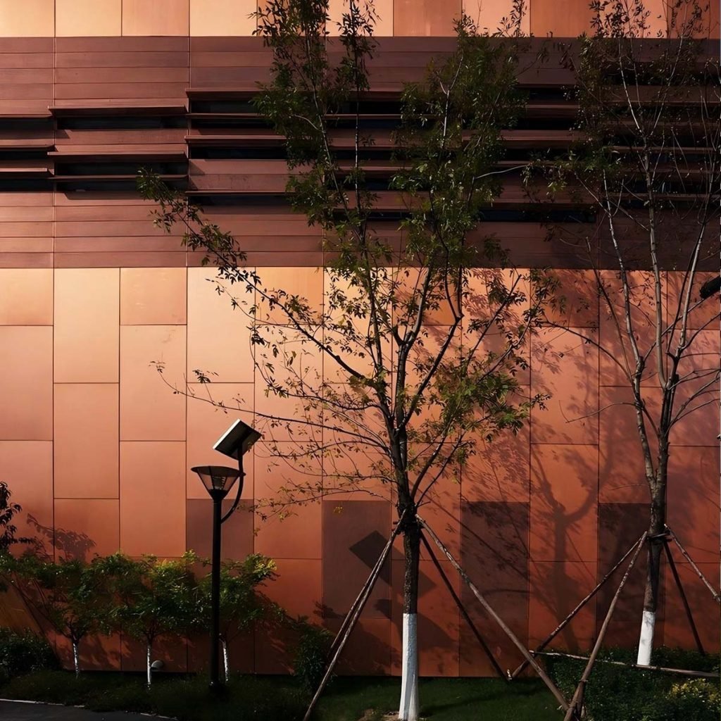 Copper facade panels forming a contemporary exterior with clean panel divisions and warm metallic tones