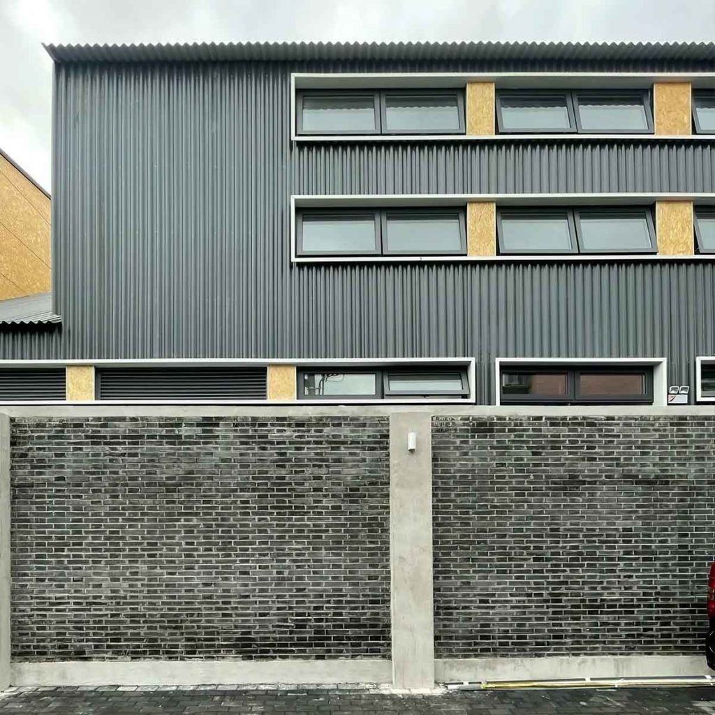 Modern corrugated metal facade cladding panels with geometric architectural exterior detailing