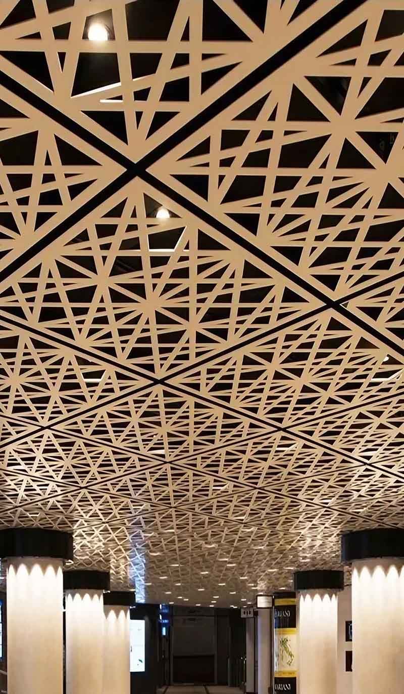 Architect showing laser-cut metal ceiling aluminium sample panels with different perforation designs for architectural customization selection