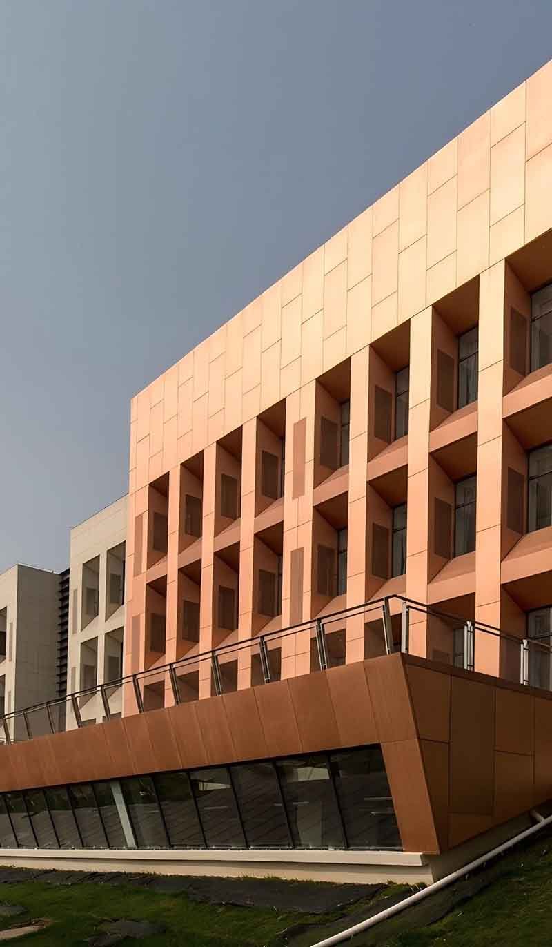 Copper facade wall cladding panels arranged across a modern building exterior with continuous vertical detailing