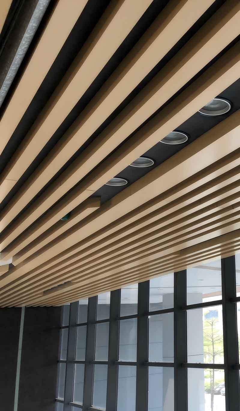 Linear metal ceiling system with linear panels for contemporary architectural interiors