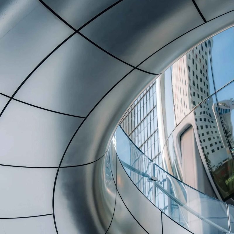 Sculptural double-curved aluminium facade panels integrated into a modern architectural building envelope