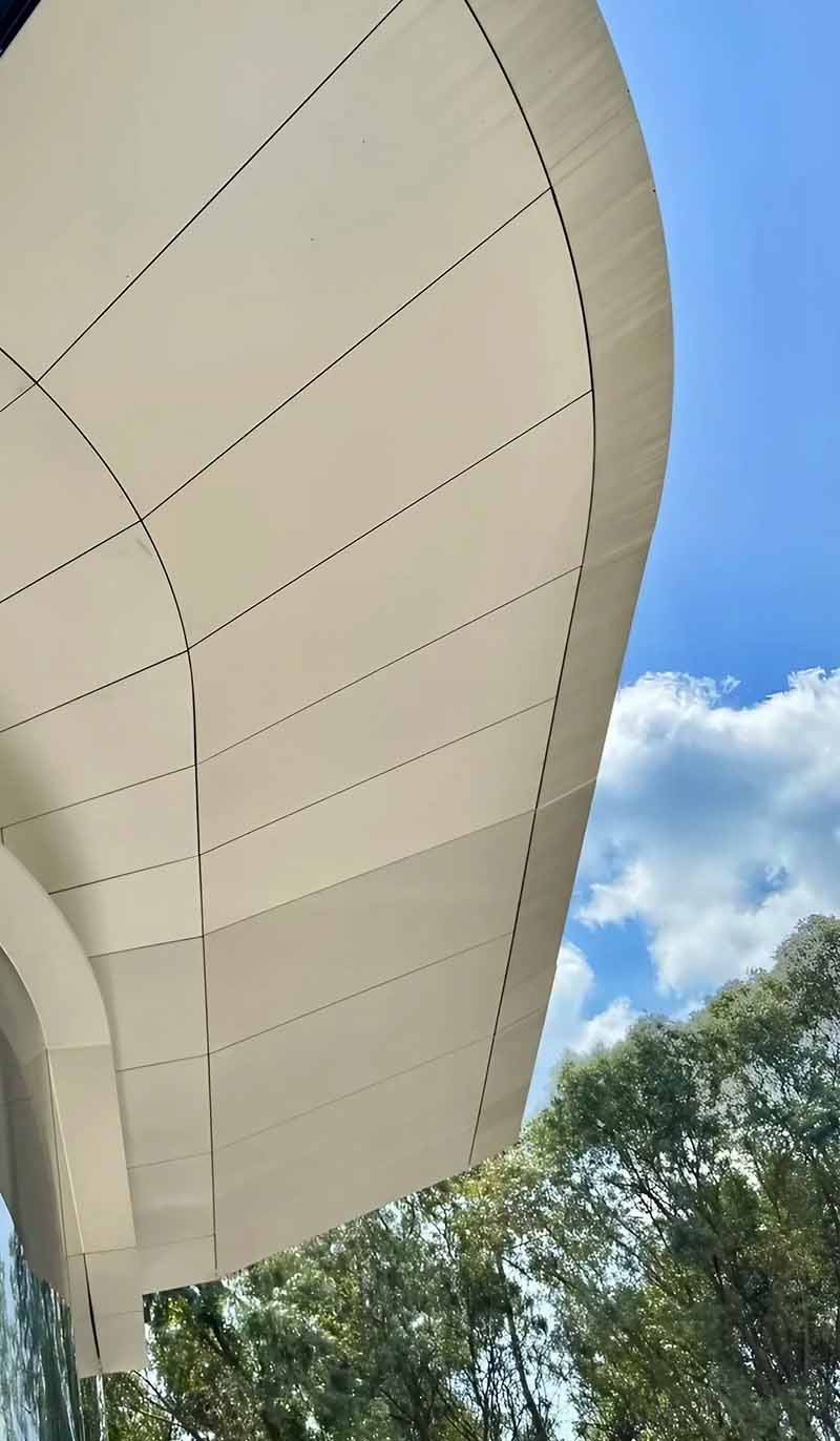Detailed double-curved aluminium facade panels following varied contours across a modern exterior wall