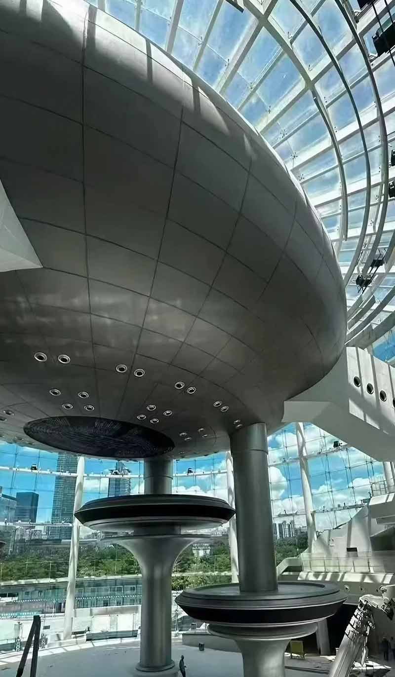 Contemporary building exterior finished with a sculpted double-curved aluminium facade
