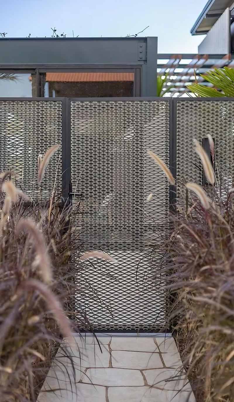 Expanded metal fence panels installed around a modern architectural project