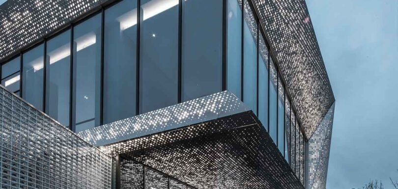 Perforated metal sheet with precision holes creating a modern architectural facade design solution