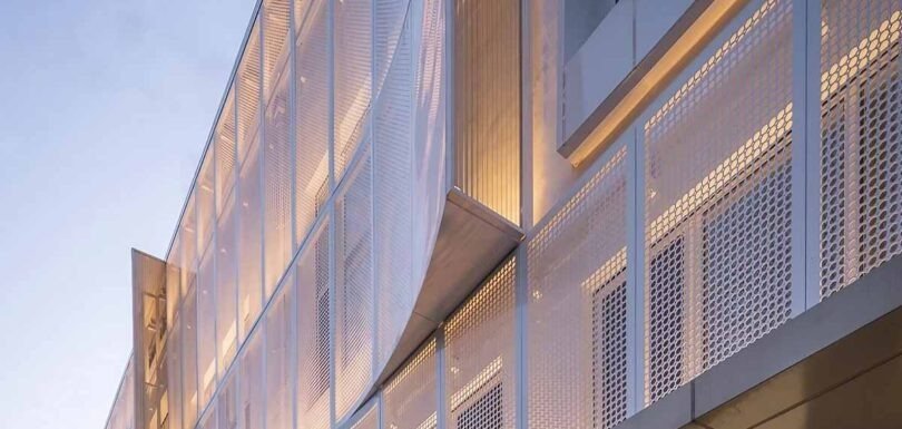 Perforated metal facade creating a sustainable exterior wall design with modern architectural patterns and ventilation features